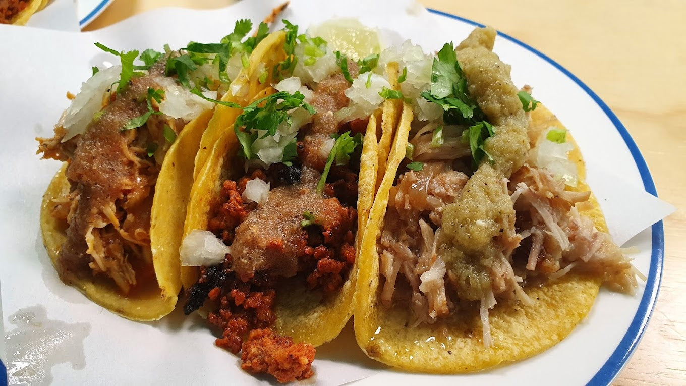 3 tacos on a plate. One is chicken tinga, chorizo and pork carnitas